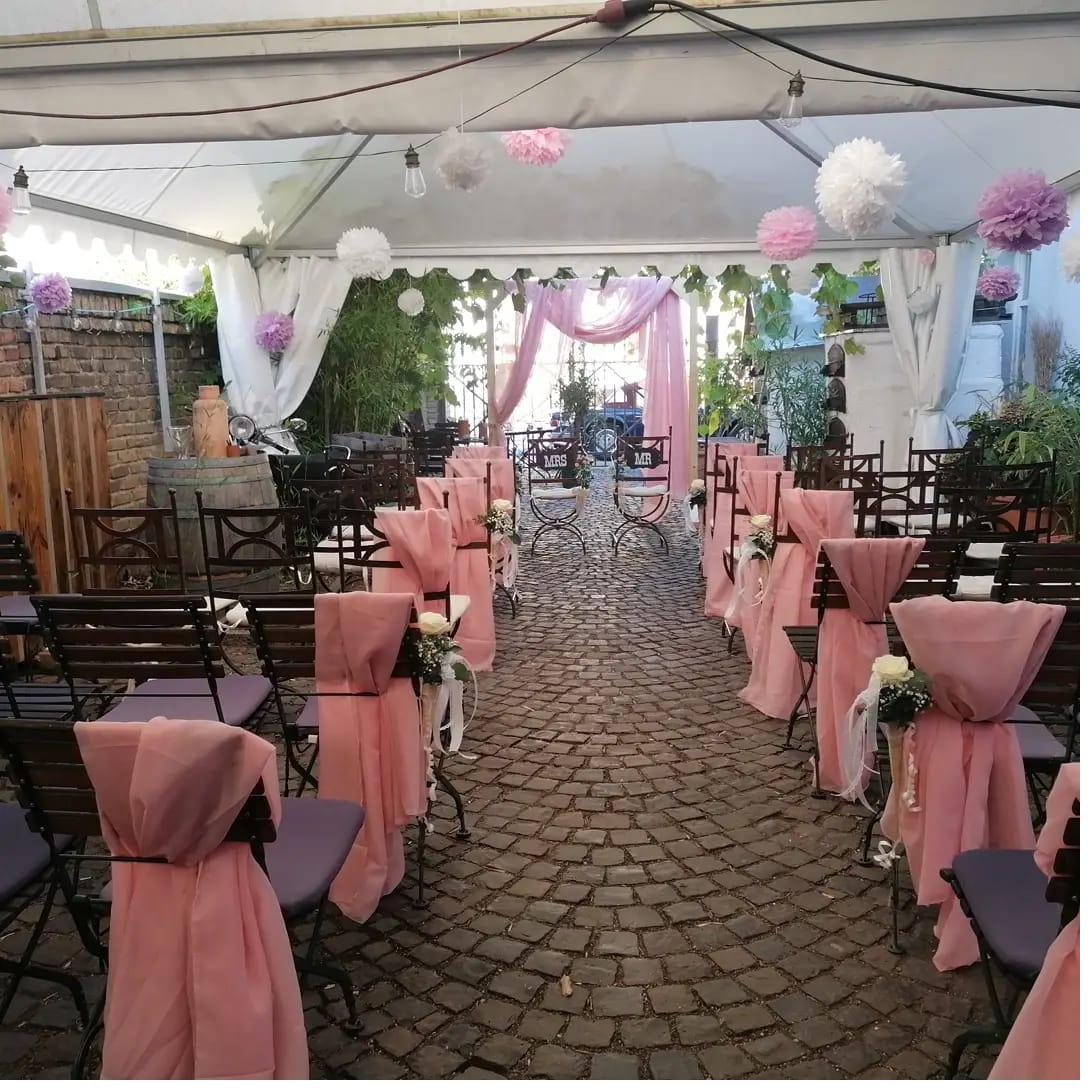 Hochzeit im Block's Ratskeller Bürstadt – romantischer Außenbereich mit rosa Stuhlhussen, Pergola und Pompoms